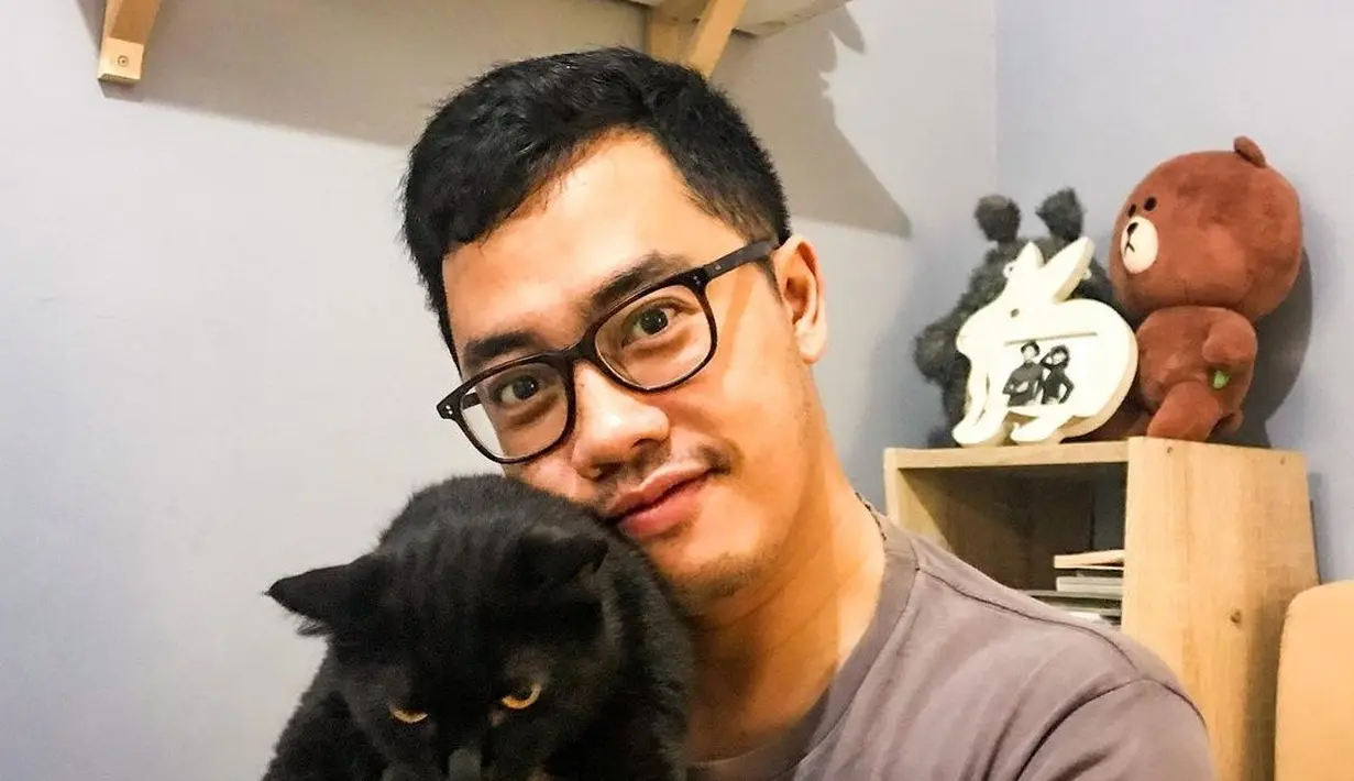 Dennis Adishwara memiliki beberapa kucing yang ia rawat dengan penuh kasih sayang. Kucing hitam yang digendong Dennis ini bernama Jiji. Jiji bahkan memiliki akun Instagram sendiri bernama @jijicat666. (Liputan6.com/IG/@dennisadishwara).