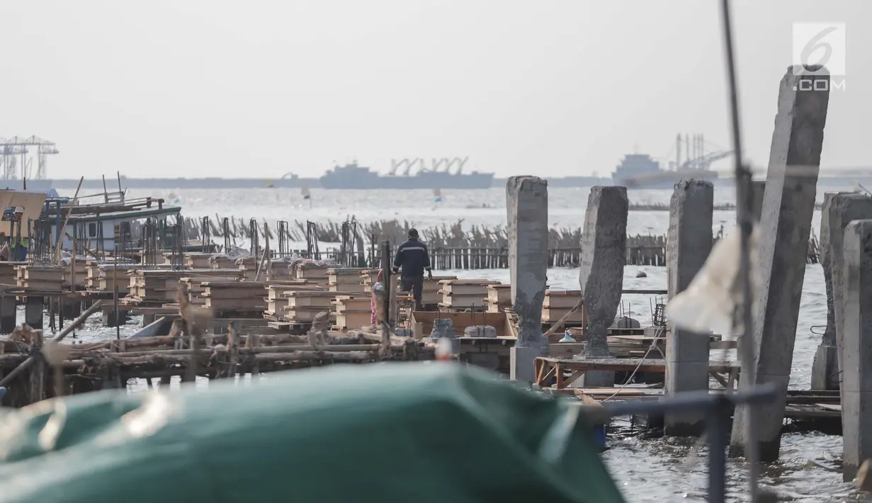 Pekerja menyelesaikan pondasi dermaga di Muara Angke, Jakarta Utara, Rabu (3/7/2019). Pemprov DKI Jakarta membangun dermaga dengan panjang mencapai 300 meter dengan lebar sekitar tujuh meter dilengkapi dengan jembatan penghubung serta pemecah ombak sepanjang 480 meter. (Liputan6.com/Faizal Fanani)