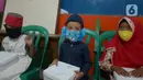 Anak-anak memakai masker di RW 11, Kelurahan Pondok Kopi, Jakarta, Jumat (18/9/2020). Di masa pandemi COVID-19, TNI dan Polri bersinergi mengimbau warga untuk mematuhi protokol kesehatan dengan memakai masker saat beraktivitas di luar rumah. (merdeka.com/Imam Buhori)