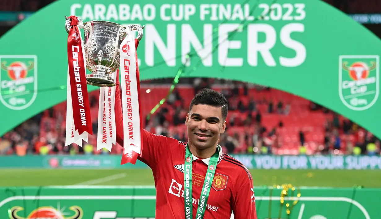 Pemain Manchester United, Casemiro mengangkat trofi Carabao Cup 2022/2023 setelah mengalahkan Newcastle dengan skor 2-0 pada laga final yang berlangsung di Stadion Wembley, London, 26 Februari 2023. Casemiro didatangkan ke Old Trafford dengan biaya 70.65 juta euro dari Real Madrid pada bursa transfer musim panas 2022/2023. Kedatangannya benar-benar mengubah peruntungan MU. Casemiro berhasil membuat klub berjuluk Setan Merah tersebut kembali keompetitif lagi. (AFP/Glyn Kirk)