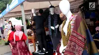 Pengunjung melihat-lihat produk kain tenun yang dipamerkan di Festival Sarung Indonesia 2019, Plaza Tenggara Kompleks GBK, Jakarta, Minggu (3/3). Festival ini diikuti sejumlah perajin sarung tenun dari berbagai daerah. (Liputan6.com/Helmi Fithriansyah)