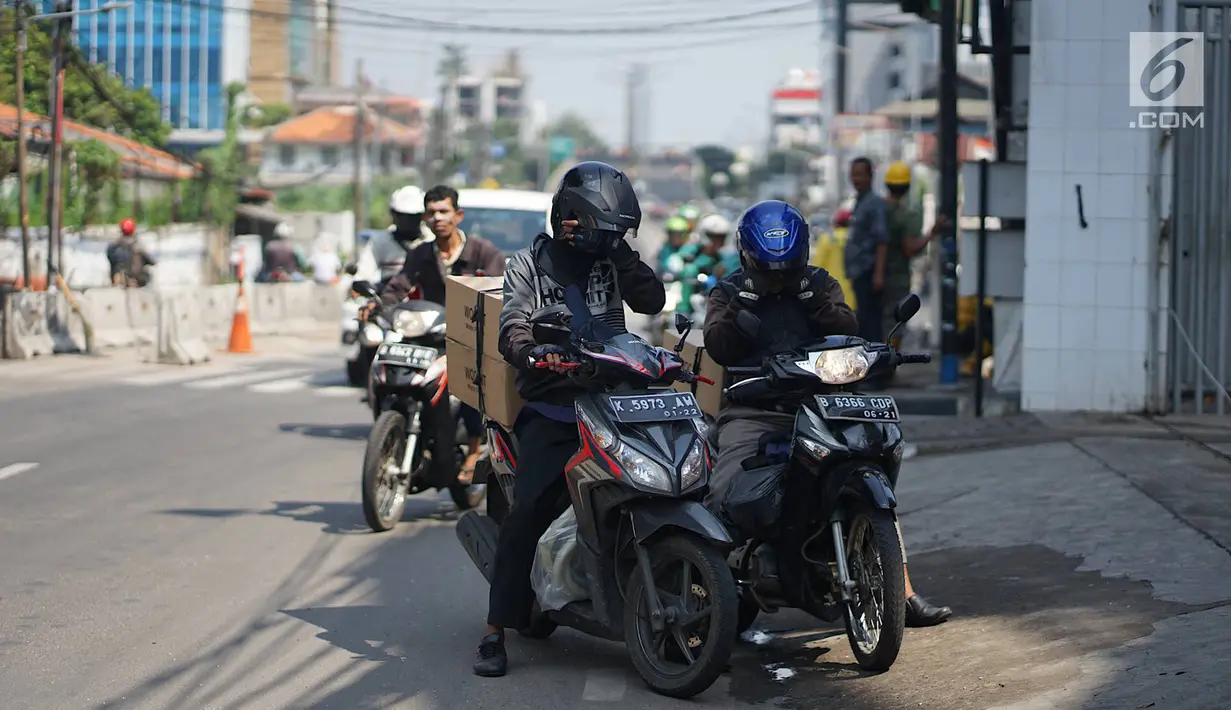 Pengendara motor berhenti saat melintas di Jalan KS Tubun, Petamburan, Jakarta Barat, Kamis (23/5/2019). Sisa gas air mata untuk membubarkan massa dalam kericuhan aksi 22 Mei masih terasa dan mengganggu aktvitas pengguna jalan, khususnya pengendara sepeda motor. (Liputan6.com/Immanuel Antonius)