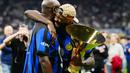 Pemain Inter Milan, Marcus Thuram, memeluk sang ayah yakni Lilian Thuram saat merayakan gelar juara Serie A di Stadion Giuseppe Meazza, (19/5/2024). Nerazzurri menjadi kampiun Liga Italia musim ini. (AFP/Marco Bertorello)