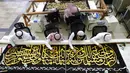 Pekerja menyulam kaligrafi Islam pada Kiswah Kabah menggunakan benang perak murni dan benang perak berlapis emas di pabrik Kiswah di Mekah, Arab Saudi, Rabu (14/7/2021). Kiswah yang menutupi Kabah diganti setiap tahun untuk umrah atau haji. (AP Photo/Amr Nabil)