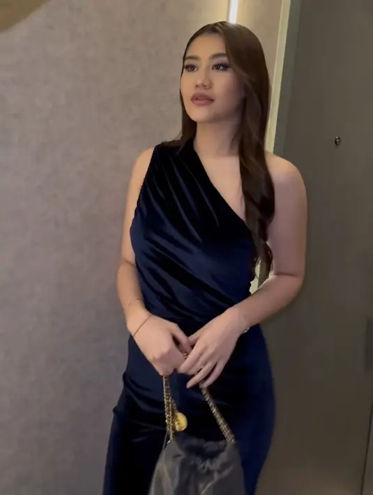 Di malam pertama berada di Singapura, Aaliyah mengenakan jumpsuit berbahan velvet model one shoulder.  [@aaliyah.massaid]