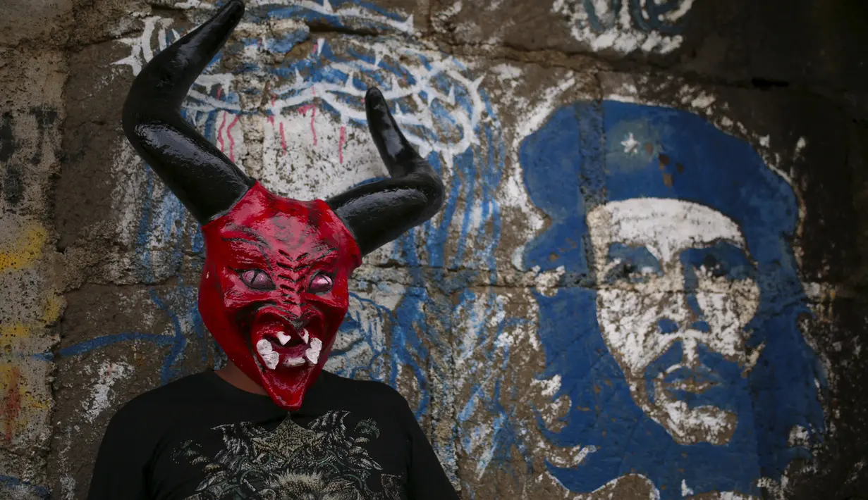 Pria mengenakan topeng yang menyerupai iblis selama festival Los Aguizotes di Masaya, Nikaragua, Jumat (18/10/2015).  Festival  ini menganjurkan para warganya untuk berpakaian layaknya karakter dari legenda dan mitologi Nikaragua.  (REUTERS/Oswaldo Rivas)