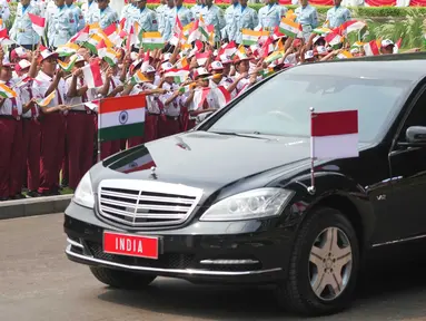 Anak-anak sekolah melambaikan bendera nasional Indonesia dan India saat iring-iringan kendaraan yang membawa Perdana Menteri India Narendra Modi melintas selama upacara penyambutan menjelang pertemuan Modi dengan Presiden Prabowo Subianto di Istana Merdeka di Jakarta,  Selasa, 7 Juli 2026. (AP Photo/Achmad Ibrahim)