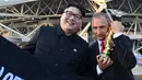 Peniru Presiden Rusia, Vladimir Putin dan pemimpin Korea Utara, Kim Jong-un berpose dengan replika piala Piala Dunia usai penyisihan Grup A antara Uruguay vs Rusia di Samara Arena, Senin (25/6). Uruguay berhasil melumat Rusia 3-0. (AFP/EMMANUEL DUNAND)