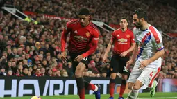 Aksi Marcus Rashford mencoba melewati pemain Crystal Palace, Luca Milivojevic pada laga lanjutan Premier League yang berlangsung di stadion Old Trafford, Manchester, Minggu (25/11). MU bermain imbang 0-0. (AFP/Lindsay Parnaby)