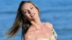 Model Afrika Selatan Candice Swanepoel berpose saat sesi pemotretan di pantai Lido menjelang pembukaan Festival Film Venesia ke-76 di Venice Lido, Italia (27/8/2019). Candice tampil cantik mengenakan blus  hijau bermotif bunga dan jeans biru ketat dengan rambut pirangnya yang terurai. (AFP Photo/Alb