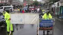 Petugas kepolisian melakukan penutupan jalan KH Hasyim Ashari, Kota Tangerang, Banten, Sabtu (16/7/2022). Intensitas curah hujan yang tinggi sejak Jumat (15/7) siang menyebabkan akses jalan Hasyim Ashari terputus karena terendam banjir setinggi 50 hingga 70 sentimeter. (Liputan6.com/Angga Yuniar)