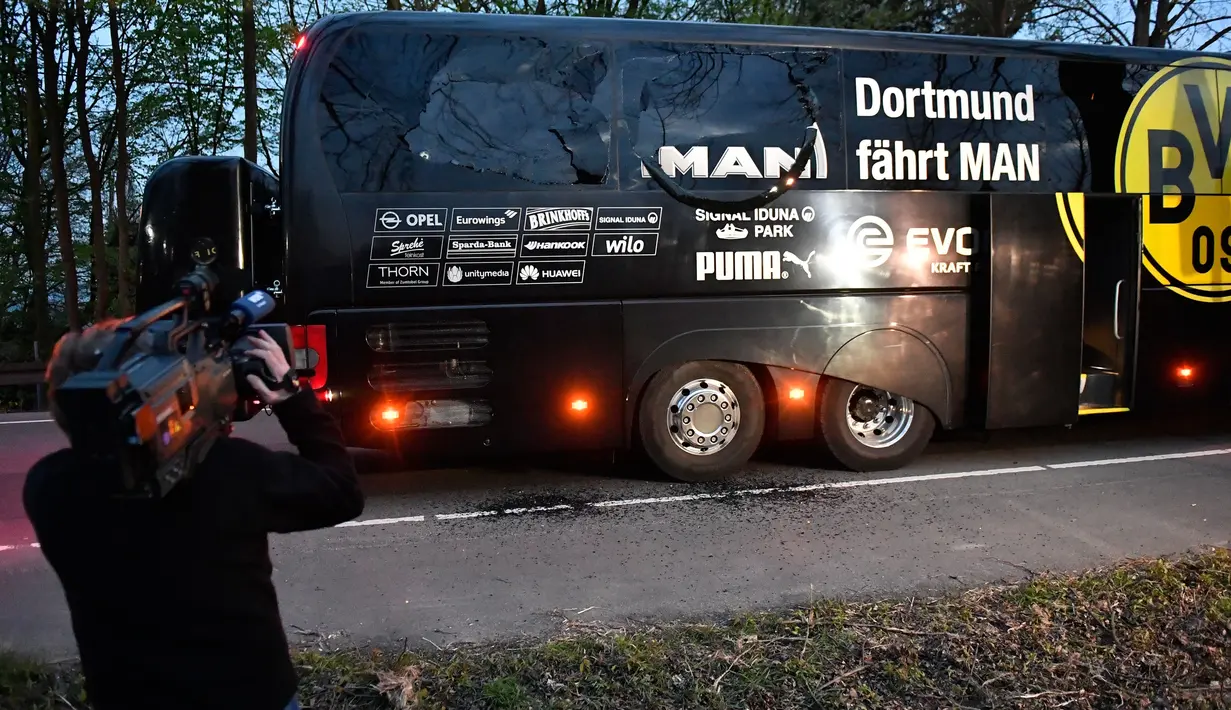 Awak media mengambil gambar kondisi bus tim Borussia Dortmund yang rusak terkena ledakan bom di Dortmund, Jerman Barat, Selasa (11/4). Dalam insiden itu, Bek Dortmund Marc Bartra mengalami luka di tangan terkena pecahan kaca. (AP Photo/Martin Meissner)