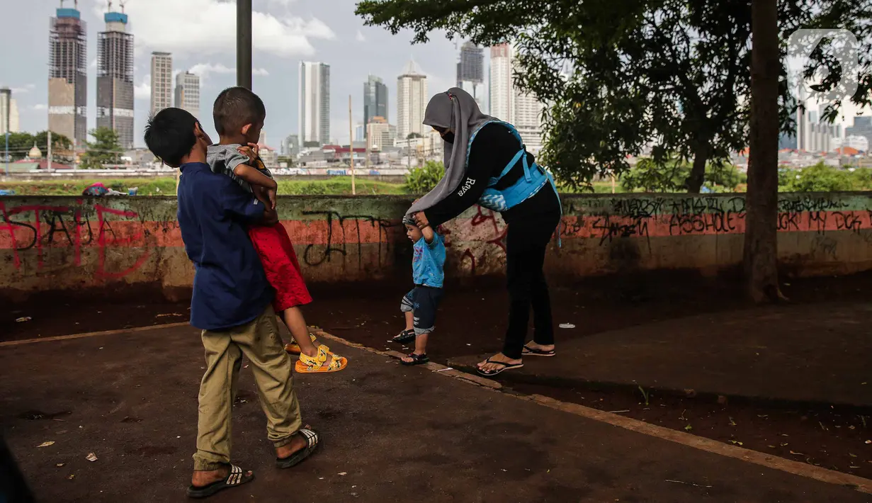 Sejumlah anak bermain di taman bermain yang terdapat di Bantaran Banjir Kanal Barat Kawasan Petamburan, Jakarta, Minggu (12/12/2021). Taman di bantaran kali kawasan padat penduduk itu menjadi sarana bermain bagi anak-anak di sekitarnya. (Liputan6.com/Faizal Fanani)