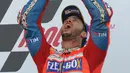 Pembalap Ducati Andrea Dovizioso, melakukan selebrasi di atas podium setelah memenangkan GP Inggris di Sirkuit Silverstone, Minggu (27/8). Dengan kemenangan ini, Dovizioso menggeser Marquez dari puncak klasemen sementara MotoGP. (AP Photo/Rui Vieira)