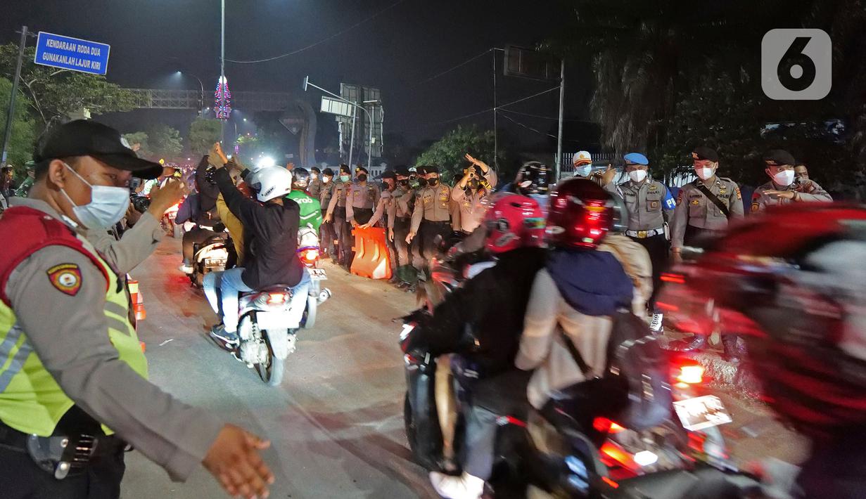 Polisi mengatur pemudik motor yang melintas di posko penyekatan mudik di Kedungwaringin, Kabupaten Bekasi, Jawa Barat, Selasa (11/5/2021) dini hari. Diskresi terhadap pemudik motor dilakukan sebagai langkah pencegahan mengurangi kerumunan. (Liputan6.com/Herman Zakharia)