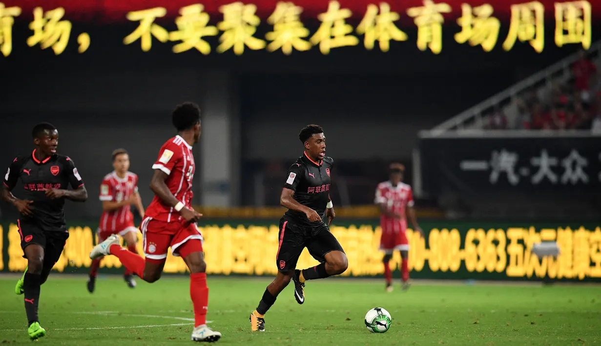 Striker Arsenal, Alex Iwobi, menggiring bola saat pertandingan melawan Bayern Munchen pada laga ICC 2017, di Stadion Shanghai, Rabu (19/7/2017). Arsenal menang adu penalti dengan skor 3-2 atas Bayern Munchen. (AFP/Johannes Eisele)