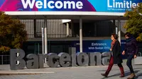 Orang-orang berjalan melewati poster yang mengumumkan Mobile World Congress (MWC) 2020 di lokasi pameran di Barcelona, Spanyol, Selasa (11/2/2020). Pembatalan MWC 2020 dilakukan setelah diadakannya pertemuan darurat oleh para petinggi penyelenggara. (AP Photo/Emilio Morenatti)