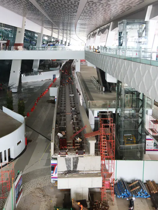 Pekerja menyelesaikan pembangunan stasiun kereta tanpa pengemudi atau APMS di Terminal 3 Bandara Soekarno Hatta, Tangerang, Senin (24/04). Moda transportasi ini akan dinikmati secara gratis bagi penumpang bandara. (Liputan6.com/Fery Pradolo)
