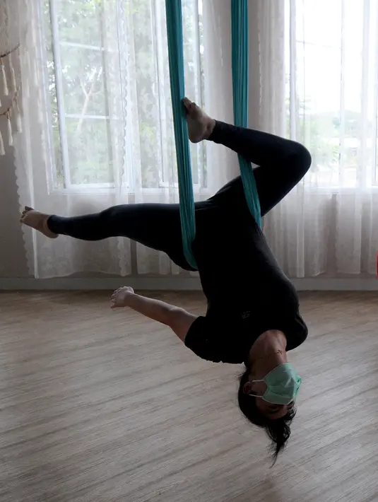 Seorang  murid melakukan gerakan aerial yoga atau yoga udara di Aerial Jooga Studia, Kelapa Dua, Tangerang, Banten, Minggu (10/10/2021). Di masa pandemi, peminat olahraga yang berasal dari Amerika Serikat ini meningkat lebih dari 60 persen. (merdeka.com/Arie Basuki)