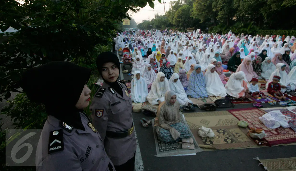 Dua polwan menjaga pelaksanaan salat Idul Fitri di depan Mapolresta Solo, Jateng, Rabu (6/7). Aksi bom bunuh diri di halaman Mapolresta Solo kemarin, tidak menyurutkan warga dan anggota untuk menunaikan ibadah salat Id di tempat tersebut. (Boy Harjanto)