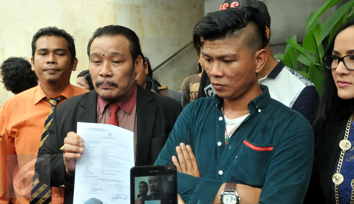 Kuasa hukum Chyntiara Alona (kiri) memperlihatkan laporan yang diajukan Alona atas penghinaan yang dilakukan EF di salah satu studio stasiun televisi swasta, Reskrimum Polda Metro, Jakarta, Senin (15/6/2015). (Liputan6.com/Panji Diksana) 