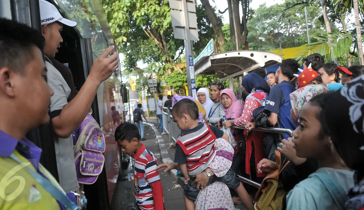 Penumpang antre menaiki bus tingkat wisata di depan halte Masjid Istiqlal, Jakarta, Minggu (30/4). Warga memanfaatkan hari libur panjang mereka dengan berkeliling Jakarta menggunakan bus tingkat ini secara gratis. (Liputan6.com/Yoppy Renato)