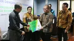 Dirut BPJS Ketenagakerjaan Agus Susanto memberikan kartu peserta usai menandatangani nota kesepahaman, Jakarta, (13/9). Kerjasama dilakukan untuk melindungi para pekerja dan pelaku usaha ekonomi kreatif yang ada di Indonesia. (Liputan6.com/Angga Yuniar)
