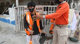 Petugas Satpol PP (kanan) menghukum warga pelanggar PSBB yang terjaring razia masker di Jalan Tanjung Duren Raya, Jakarta, Jumat (11/9/2020). Petugas Satpol PP gencar melakukan razia masker menyusul kasus COVID-19 di DKI Jakarta yang terus meningkat. (merdeka.com/Imam Buhori)