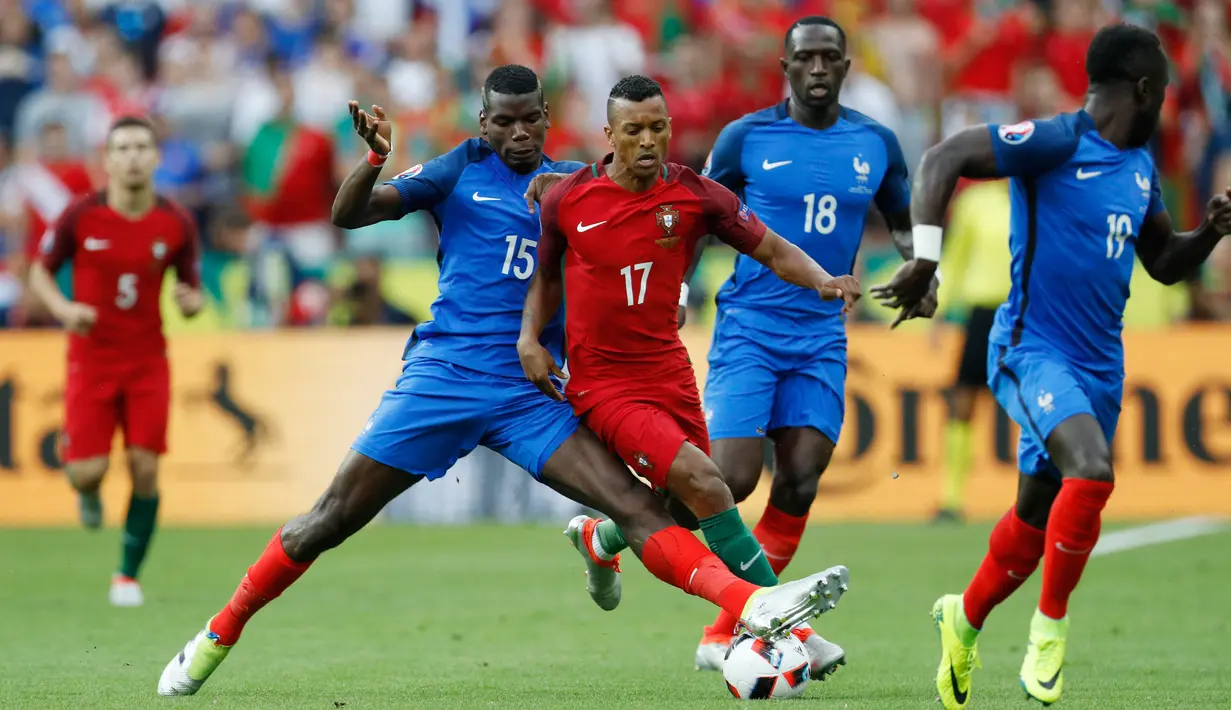 Paul Pogba (kiri) berusaha merebut bola dari Nani saat laga final antara Portugal dan Prancis di Stade de France, Senin (11/7). Portugal keluar sebagai juara usai mengalahkan Prancis dengan skor 1-0. (REUTERS)
