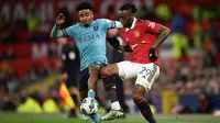 Bek Burnley, Ian Maatsen (kanan) berebut bola dengan bek Manchester United, Aaron Wan-Bissaka pada laga putaran keempat Piala Liga Inggris 2022/2023 di Old Trafford Stadium, Manchester (21/12/2022). Ian Maatsen dipinjam Burnley dari Chelsea U-21 pada awal musim 2022/2023. Pemain asal Belanda ini telah tampil dalam 34 laga di Championship dengan torehan 4 gol dan 6 assist. (AFP/Oli Scarff)