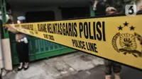 Petugas kepolisian saat memasang garis batas polisi sebelum berlangsungnya pembongkaran makam di kawasan Buaran, Jakarta Timur, Senin (24/5/2021). Nantinya pihak RSCM akan melakukan tiga penelitian dalam autopsi, yakni Pantologi Klinis, Pantologi Anatomi, dan Pantologi Makrofis Mikrofis. (merdeka.co