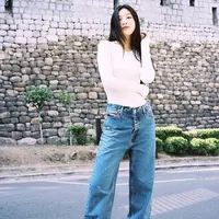 Joy mengenakan boot cut jeans yang dipadukan dengan long slevee putih. Sepatu sneakers pun membuat tampilannya lebih simple dan nyaman. Dok. Instagram @_imyour_joy