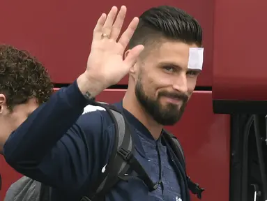 Penyerang Timnas Prancis,  Olivier Giroud melambaikan tangan sebelum menaiki pesawat menuju Rusia di bandara Bron, Lyon, Minggu (10/6). Giroud ikut dalam rombongan yang akan berlaga di Piala Dunia 2018 meski sedang kondisi cedera. (AFP/PHILIPPE DESMAZES)
