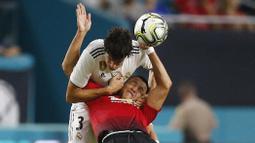 Striker Manchester United, Alexis Sanchez, duel udara dengan bek Real Madrid, Jesus Vallejo, pada laga ICC 2018 di Miami Gardens, Rabu (1/8/2018). Manchester United menang 2-1 atas Real Madrid. (AP/Brynn Anderson)