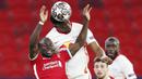 Pemain RB Leipzig, Nordi Mukiele, duel udara dengan penyerang Liverpool, Sadio Mane, pada laga Liga Champions di Puskas Arena, Kamis (11/3/2021). Liverpool menang dengan skor 2-0. (AP/Laszlo Balogh)