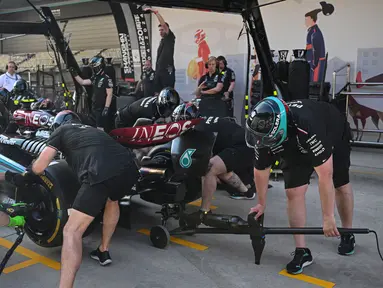 Para mekanik melakukan latihan pit stop dengan mobil pembalap Mercedes asal Inggris, Lewis Hamilton di Shanghai pada 18 April 2024. (Pedro PARDO/AFP)