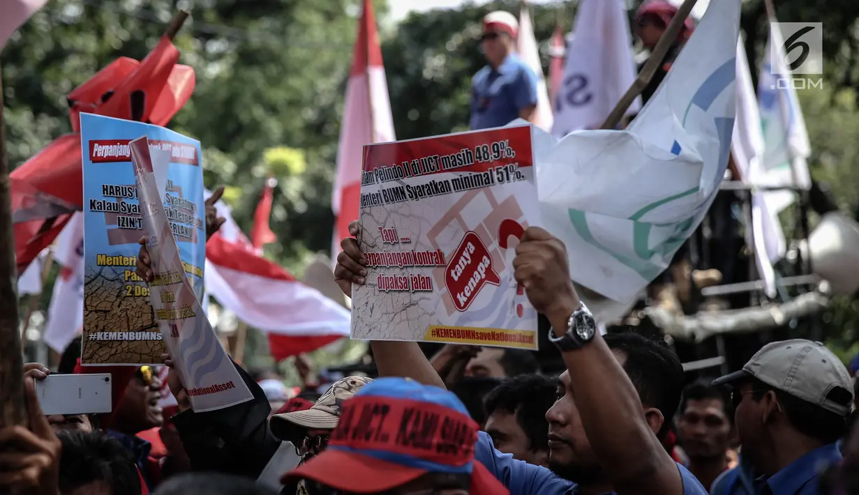 Peserta demo menunjukan poster saat menggelar aksi unjuk rasa di depan kantor Kementerian BUMN, Jakarta, Senin (31/7). (Liputan6.com/Faizal Fanani)