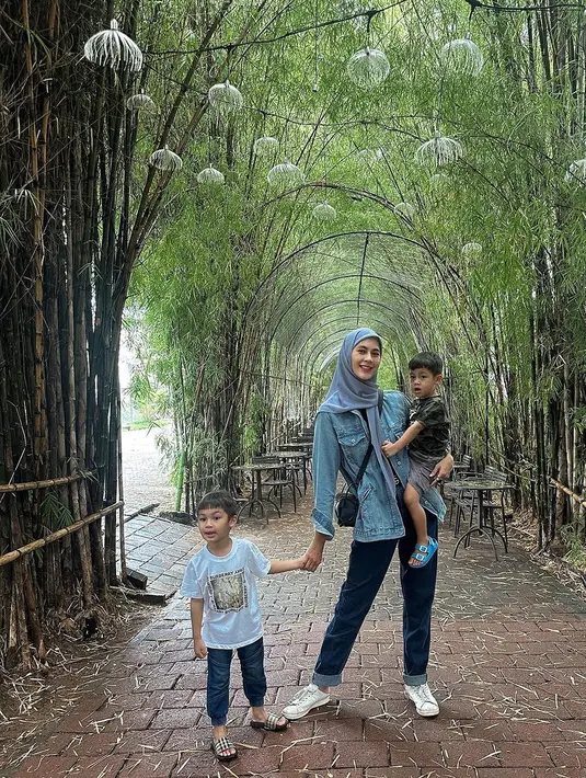 Gaya keibuan Paula Verhoeven dengan kedua anaknya pakai outfit denim on denim. Paula memadukan jaket jeansnya dengan celana jeans, dan hijab abu-abu polos, serta sneakers putih. [Foto: Instagram/paula_verhoeven]