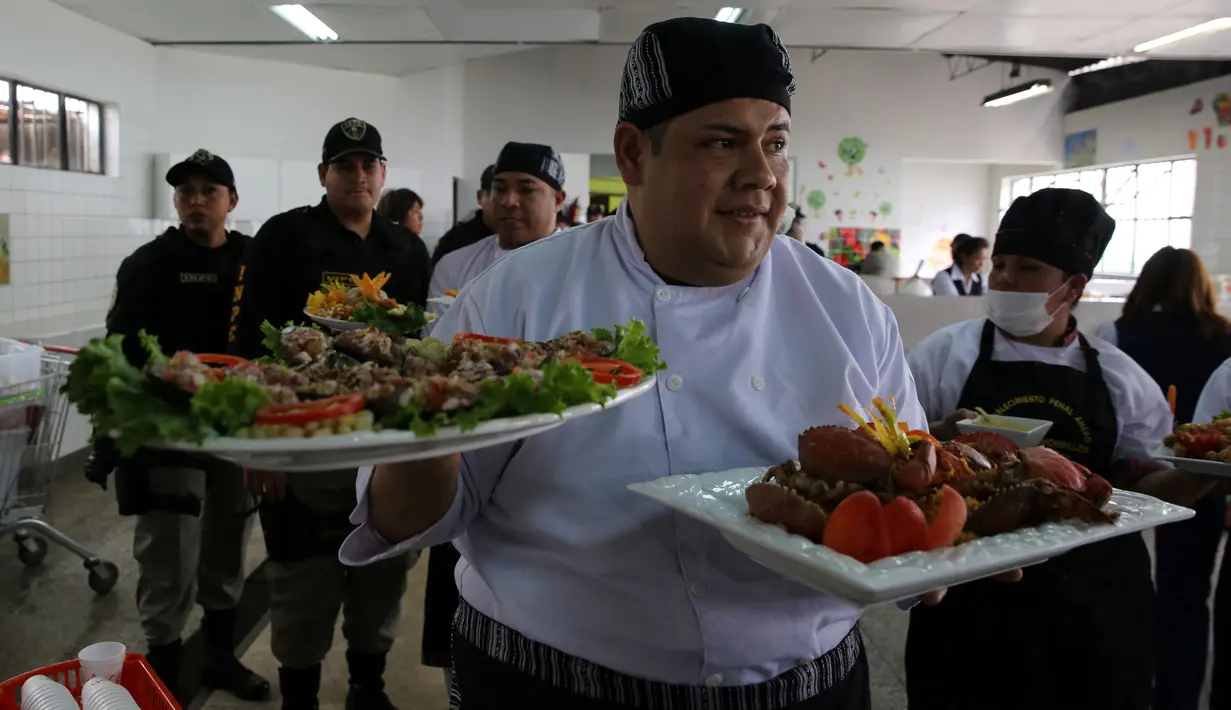 Narapidana membawa makanannya untuk dinilai oleh dewan juri dalam kompetisi kuliner 'INPE Mistura 2016' di penjara perempuan Chorrillos di Lima, Peru, Rabu (7/9). Sejumlah penjaga penjara memperhatikan dan mengawasi secara seksama. (REUTERS/Mariana Bazo)