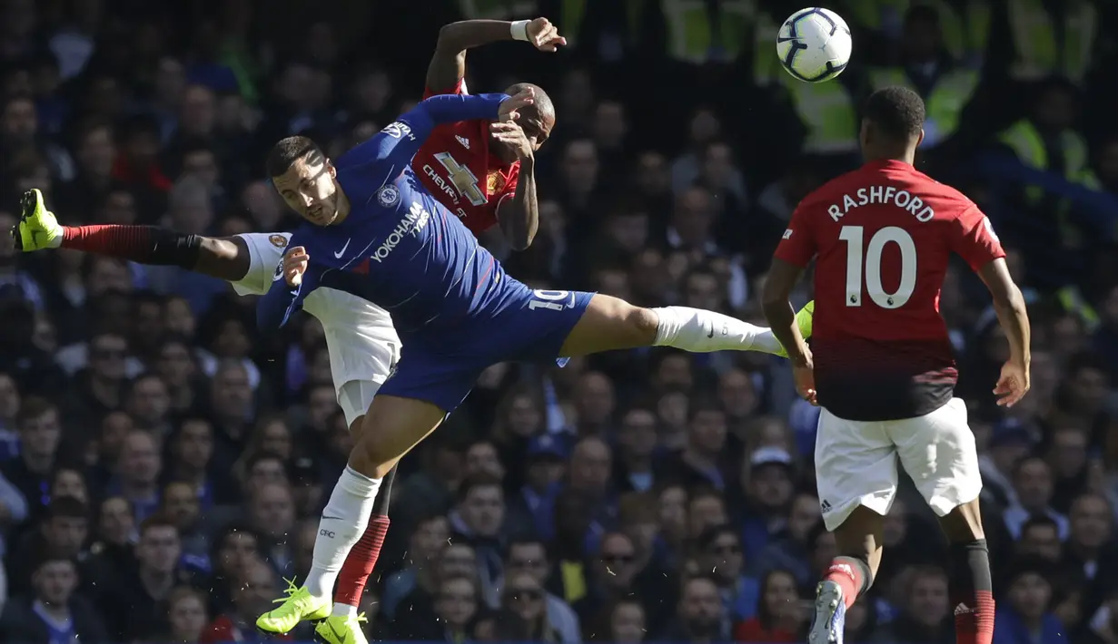 Penyerang Chelsea, Eden Hazard, duel udara dengan gelandang Manchester United, Ashley Young, pada laga Premier League di Stadion Stamford Bridge, Sabtu (20/10/2018). Kedua tim bermain imbang 2-2. (AP/Matt Dunham)
