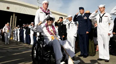 Tentara memberikan hormat kepada veteran perang Pearl Harbor, Robert Coles sebelum upacara peringatan ke-75 tahun pengeboman Pearl Harbor di Honolulu, Hawaii (7/12). (Reuters/Hugh Gentry)
