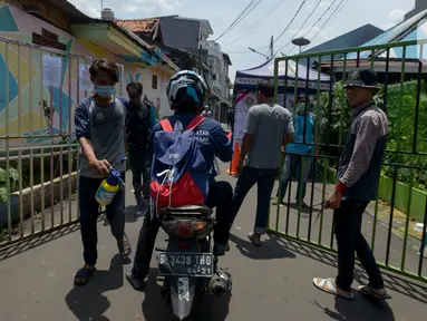 Anggota Karang Taruna menyemprotkan cairan disinfektan ke kendaraan yang memasuki pemukiman di Kelurahan Kebon Sirih, Jakarta, Rabu (1/4/2020). Warga di kelurahan itu memberlakukan akses satu pintu masuk dan menyemprotkan disinfektan guna mencegah penyebaran virus COVID-19. (merdeka.com/Imam Buhori)