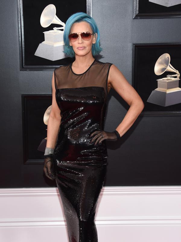 Aktris sekaligus model, Jenny McCarthy berpose di karpet merah Grammy Awards 2018, New York, Minggu (28/1). Penampilan tak istimewa Jenny McCarthy mengenakan gaun berbahan PVC yang mengilap, kacamata hitam berikut wig biru. (Evan Agostini/Invision/AP)