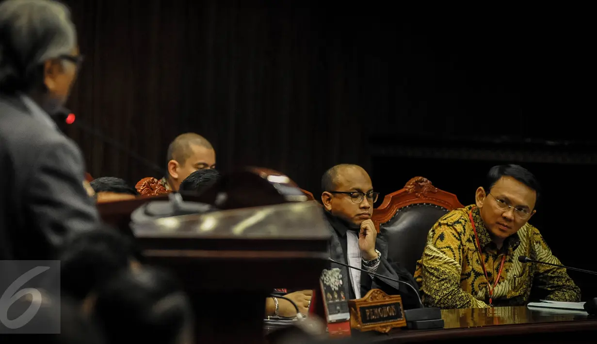 Gubernur DKI Basuki Tjahaja Purnama (Ahok) mendengarkan keterangan saksi ahli mantan hakim Mahkamah Konstitusi (MK), Harjono, dalam sidang lanjutan uji materi UU Pilkada terkait cuti kampanye di MK, Jakarta,  Senin (26/9). (Liputan6.com/Faizal Fanani)