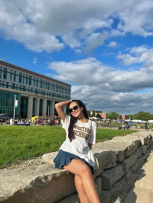 Di hari pertama masuk kuliah, Beby tampil manis memadukan kaos putih berlogo kampus dengan rok mini jeans plus sneakers putih. (Instagram/bebytsabina).