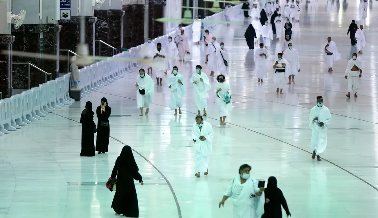 Warga Saudi dan asing tiba untuk mengelilingi Ka'bah (tawaf) saat melaksanakan umrah di kompleks Masjidil Haram, kota suci Makkah, Minggu (4/10/2020). Arab Saudi mengizinkan kembali ibadah umrah usai peringanan pembatasan sosial dan karantina wilayah di tengah pandemi Covid-19 di Tanah Suci. (AFP)