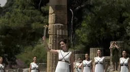 Aktris Yunani, Katerina Lechou, mengangkat obor api olimpiade yang baru saja dinyalakan dalam suatu upacara di Candi Hera yang terletak di bekas kota tua Olympia, Yunani, Kamis (21/4/2016). (AFP/Aris Messinis)