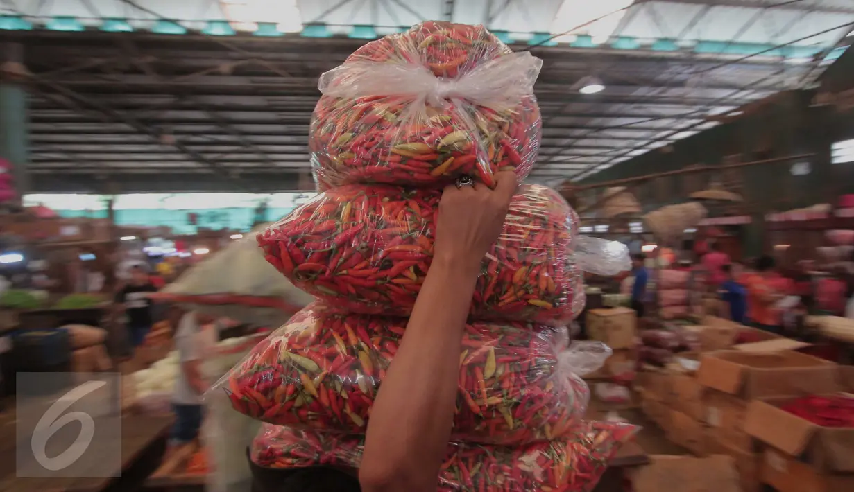 Pedagang memanggul plastik cabai di Pasar Induk Kramat Jati, Jakarta, Selasa (24/11). Harga cabai merah keriting kini dipatok Rp 25 ribu per kg, sementara cabai merah rawit dipatok Rp 28 ribu per kg. (Liputan6.com/Angga Yuniar)