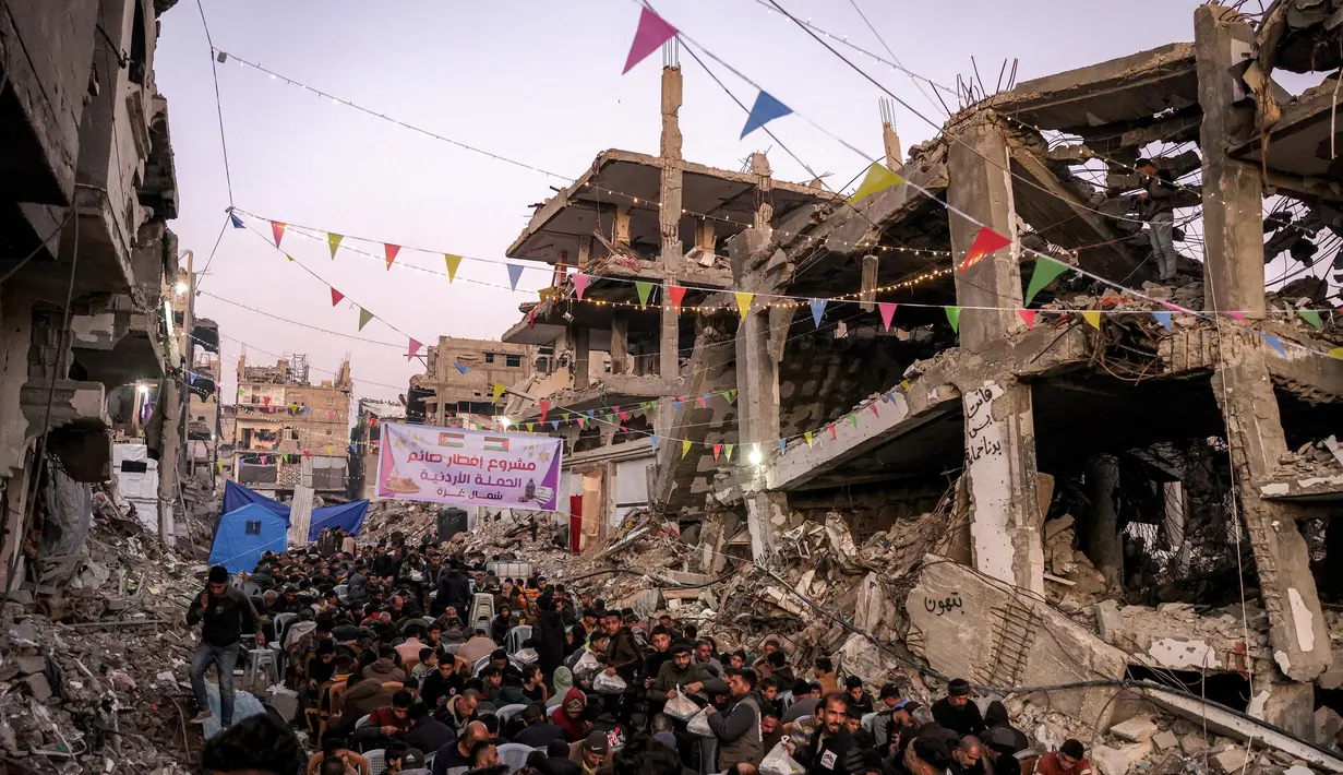 Orang-orang berkumpul untuk berbuka puasa pada hari pertama bulan puasa Ramadan di Jabalia, Jalur Gaza utara, pada 1 Maret 2025. (Bashar TALEB/AFP)