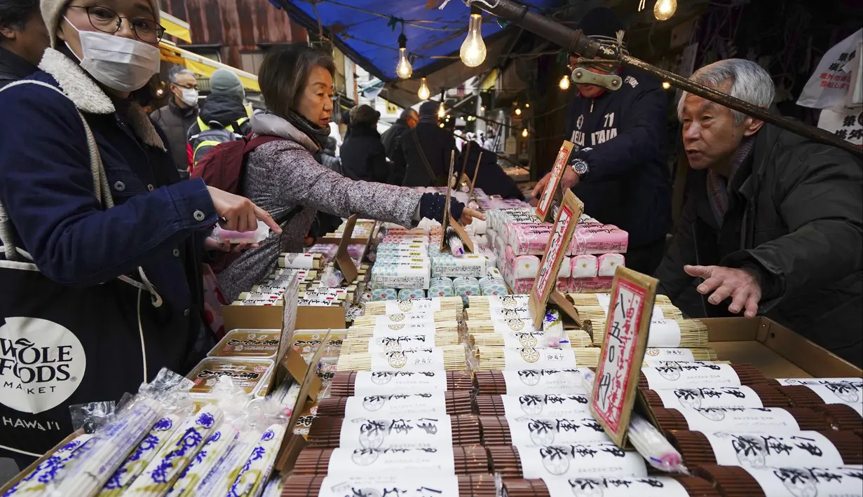 Warga membeli bahan-bahan untuk membuat makanan tahun baru atau osechi di Pasar Tsukiji, Tokyo, Jepang, Kamis (26/12/2019). Osechi terdiri dari berbagai jenis makanan istimewa. (AP Photo/Eugene Hoshiko)